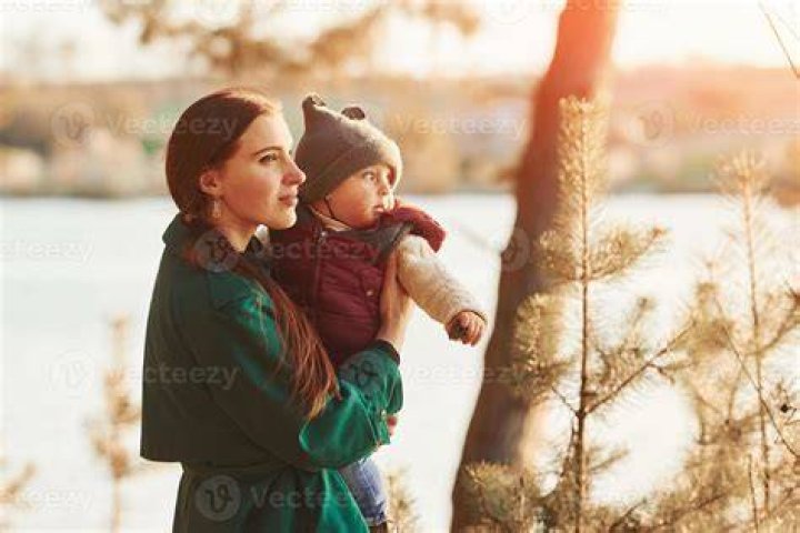 Mother with Her Little Son Enjoying Bathing in Wooden Barrel Hot Tub in