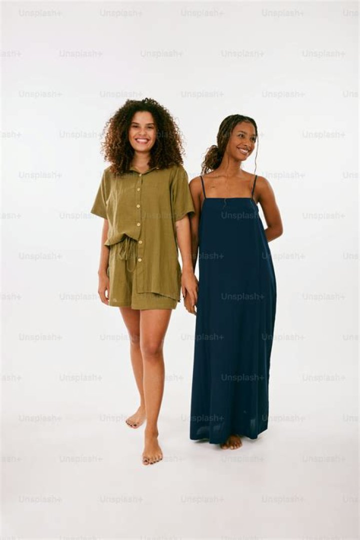 two women standing next to each other on a red carpet