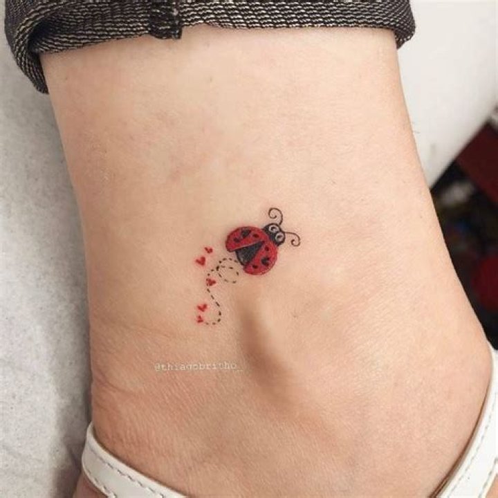 Wonderful small colorful lovebug tattoo on finger